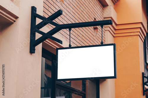 Empty signage and blank mock up hanging on street with copy space
