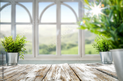 Fototapeta Naklejka Na Ścianę i Meble -  White wooden window with summer landscape and small green plant on white wooden table 