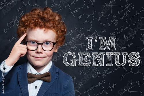 Genius child on blackboard background with science and maths formulas