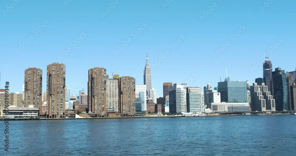 Moving shot of Empire State Building with buildings in front and back from East River. Moving shot of Empire State Building with buildings in front and back from East River.
