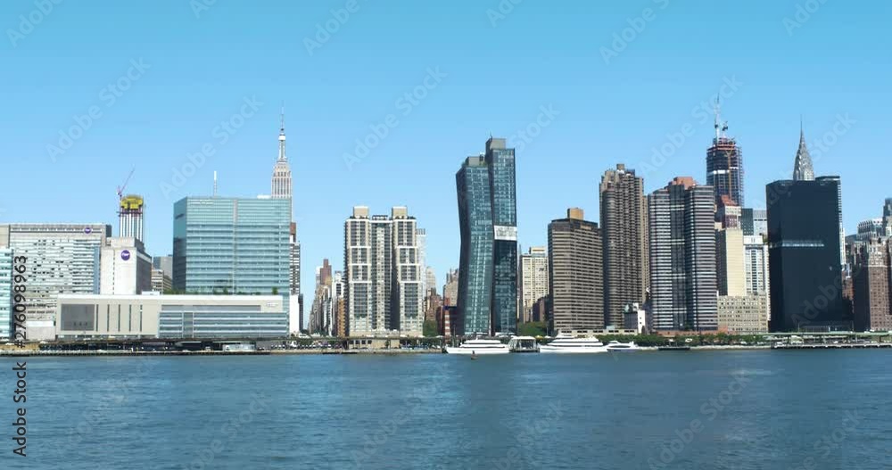 Side moving shot of midtown Manhattan skyline from East River. Side moving shot of midtown Manhattan skyline from East River.