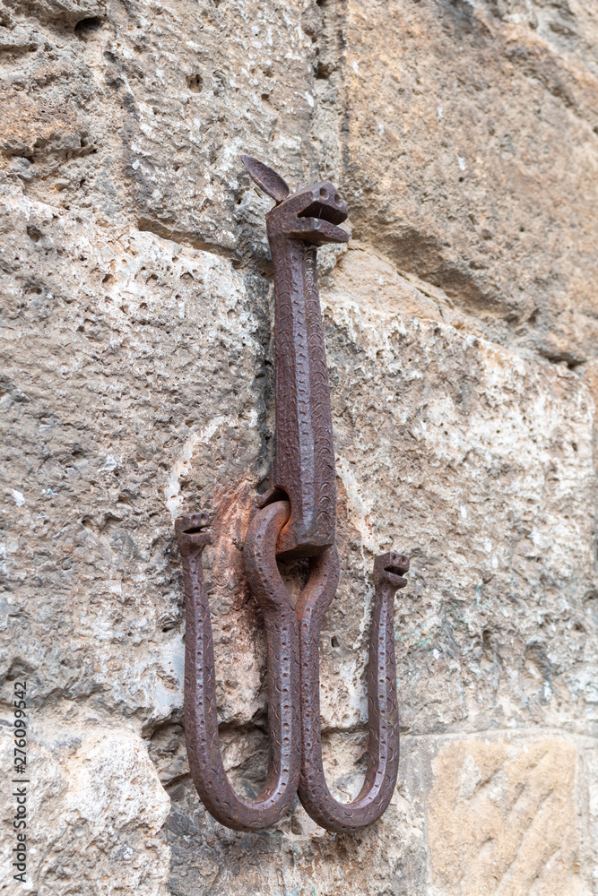 Medieval wall hook on stone building exterior in San Gimignano, Italy