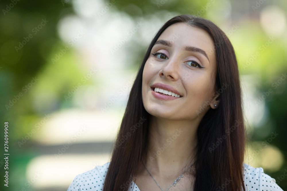 Portrait of beautiful young happy smiling woman, outdoors, with copy space.