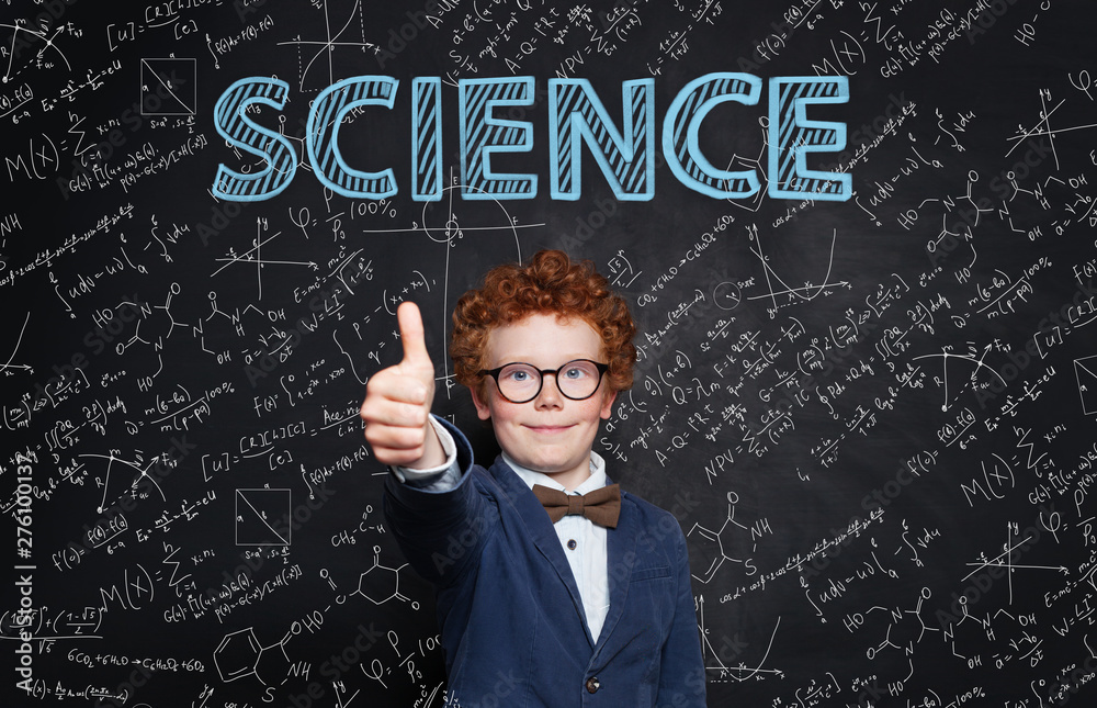Happy child student holding thumb up on blackboard background with science and maths formula. Learn science Happy child student holding thumb up on blackboard background with science and maths formula. Learn science