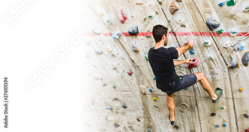 Man practicing rock climbing on artificial wall indoors. Active lifestyle and bouldering concept with copy space.