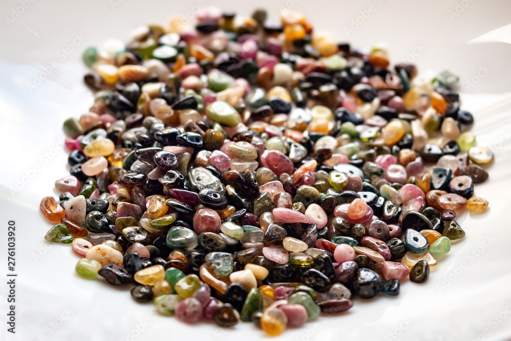Obraz premium Tourmaline stone beads on white background.