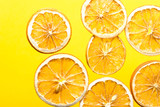 Pattern from homemade oven dried dehydrated citrus fruits oranges on bright yellow background. Ingredient for winter fall hot beverages pastry. Culinary poster