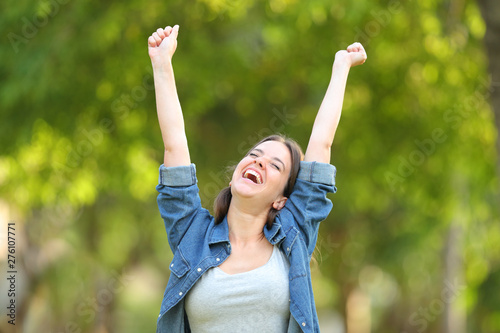 Excited woman celebrating success raising arms