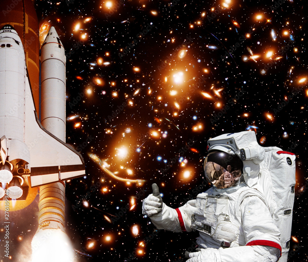 Astronaut gives thumbs-up, rocket and galaxy on the backdrop. The elements of this image furnished by NASA. Astronaut gives thumbs-up, rocket and galaxy on the backdrop. The elements of this image furnished by NASA.