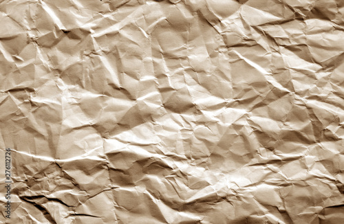 Crumpled sheet of paper with blur effect in brown color. photo