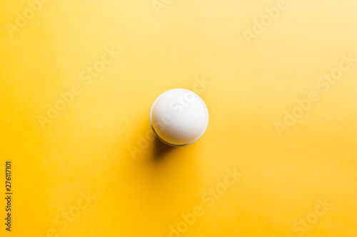 White egg on the yellow background in center. Pop art design minimalism style