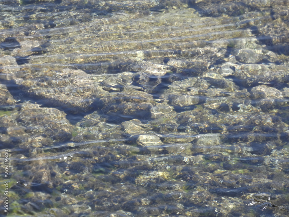 Vista interior del agua de una cala, se ven las piedras, las rocas debajo del agua, agua transparente y cristalina