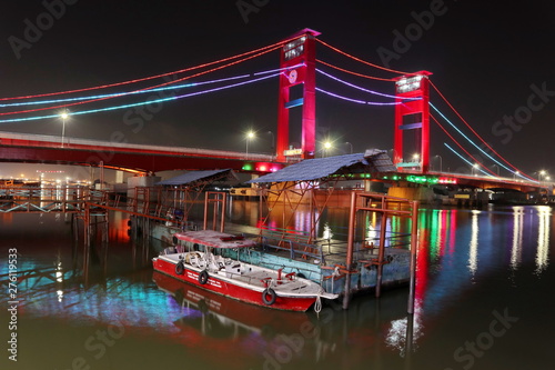 Palembang's Ampera bridge is photographed at night, with natural lighting and slow speed photography techniques. photo