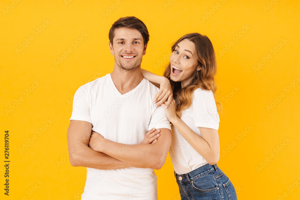 Portrait of joyous couple man and woman in basic t-shirts smiling and hugging together Portrait of joyous couple man and woman in basic t-shirts smiling and hugging together
