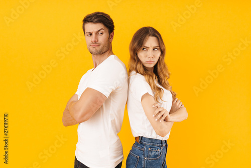 Foto Portrait of serious offended couple man and woman in basic t-shirts standing bac