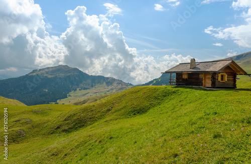 road and houses, green fields at Dolomites mountains, Odle Puez, Italy