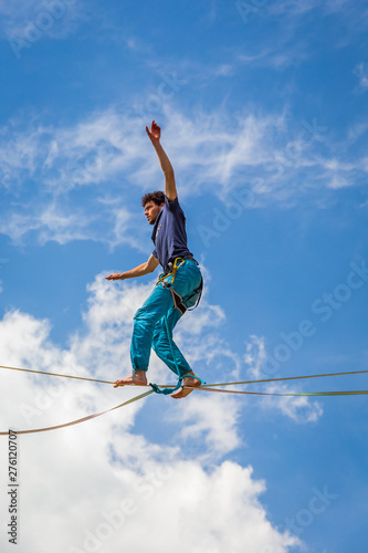 Young slackliner man balancing on a slackline betweend two rocks. Highline with a beautiful natural landscape behind