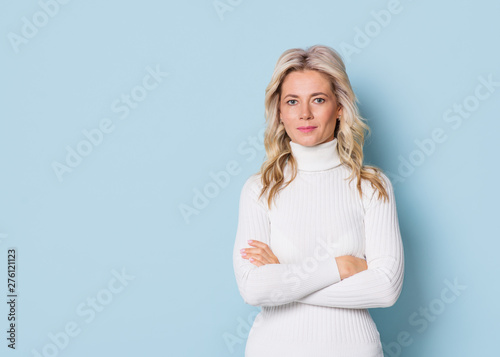 Blonde woman adult attractive beautiful portrait en face, cauasian and scandinavian girl on blue background photo