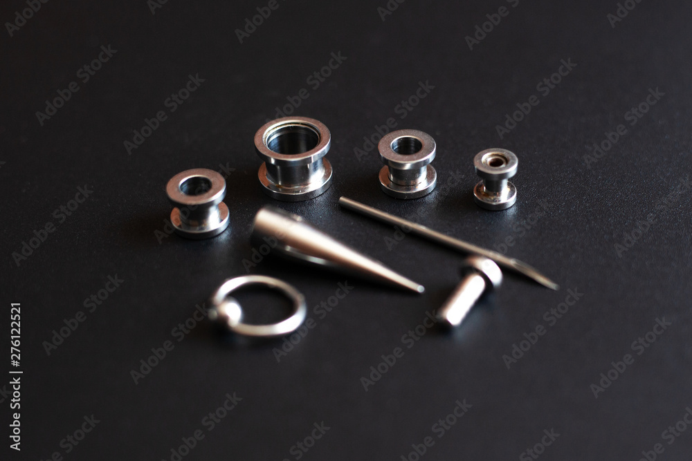 set of accessories for piercing on a dark background set of accessories for piercing on a dark background