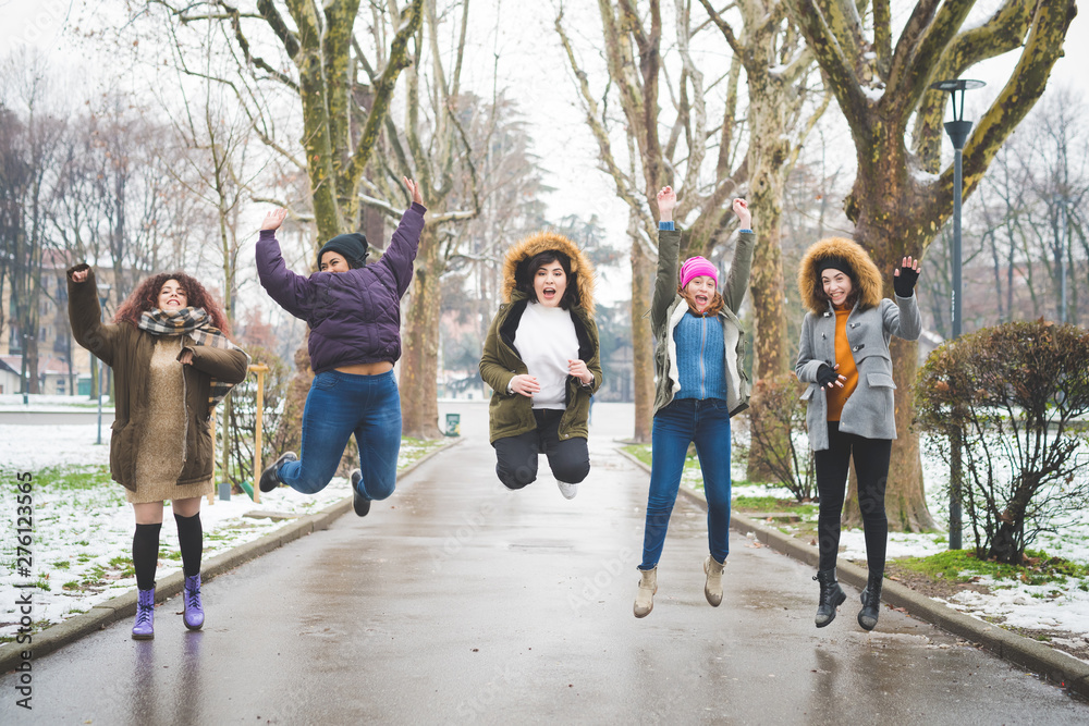 Obraz premium group of women jumping in tree lined avenue