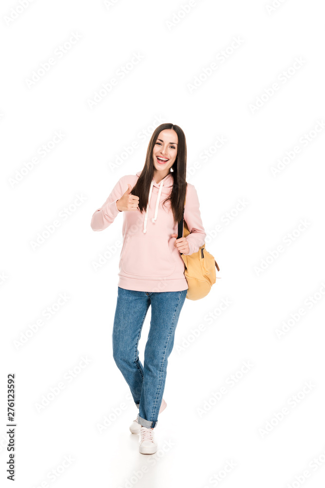 full length view of smiling brunette girl with backpack showing thumb up isolated on white full length view of smiling brunette girl with backpack showing thumb up isolated on white