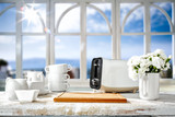 White wooden desk in kitchen and blurred background of window and summer landscape of sun and sea 