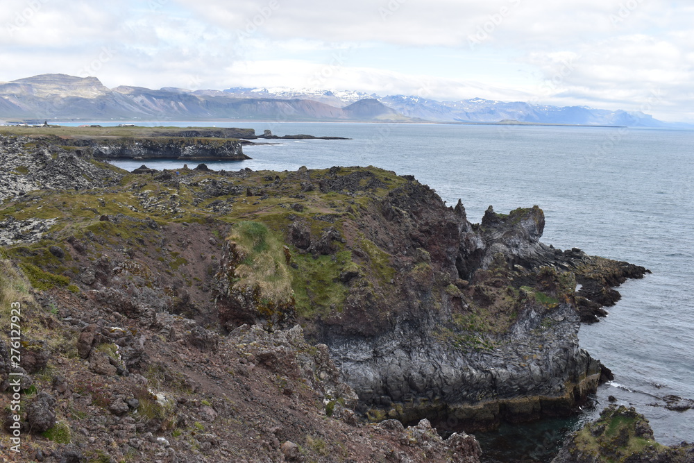 Hiking trail from Anarstapi to Hellnar with the raw ocean und big rocks and mountains in the west of Iceland at Snaefellsnes Peninsula