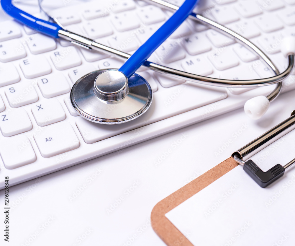 Stethoscope on computer keyboard on white background. Physician write medical case long term care treatment concept, close up, macro, copy space Stethoscope on computer keyboard on white background. Physician write medical case long term care treatment concept, close up, macro, copy space