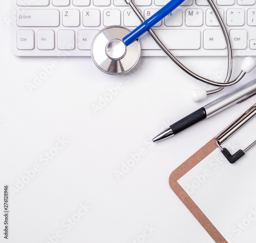 Stethoscope on computer keyboard on white background. Physician write medical case long term care treatment concept, top view, flat lay, copy space