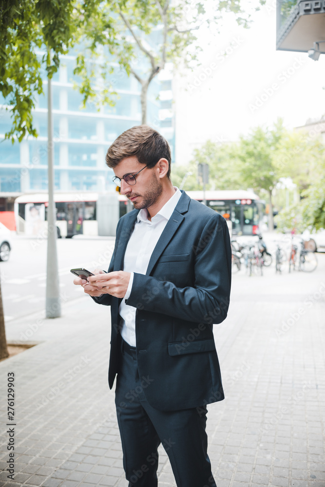 Portrait of a businessman standing on street using mobile phone Portrait of a businessman standing on street using mobile phone