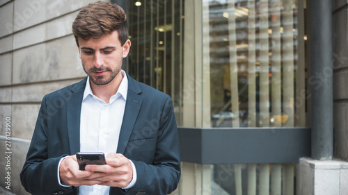 Young businessman texting on the smartphone