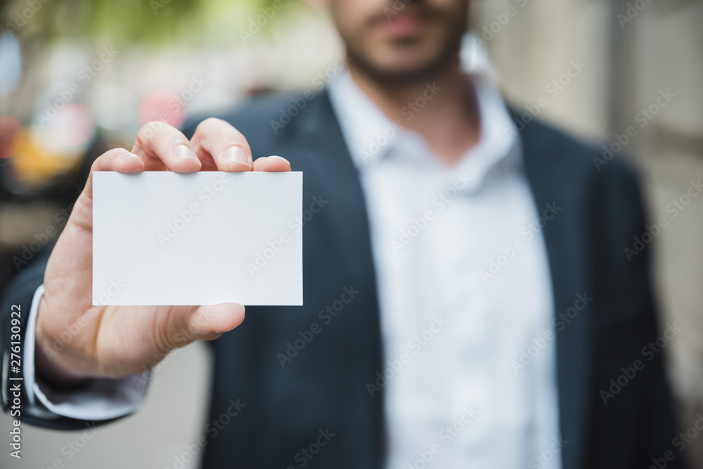 Close-up of businessman's hand showing white visiting card Close-up of businessman's hand showing white visiting card