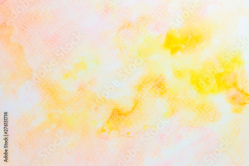 Abstract yellow and pink watercolor on paper. The color splashing in the paper. It is a hand drawn. 