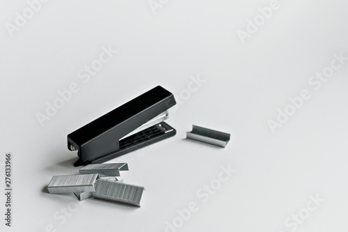 Stapler black with paper clips isolated on white background.