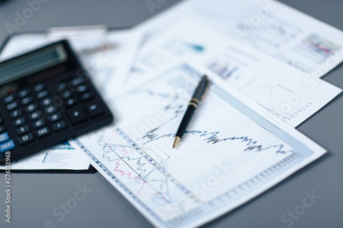 close up.pen, financial chart and calculator on the desktop