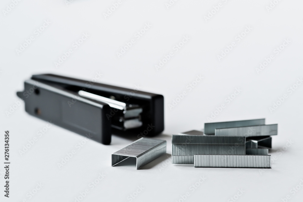Stapler black with paper clips isolated on white background.