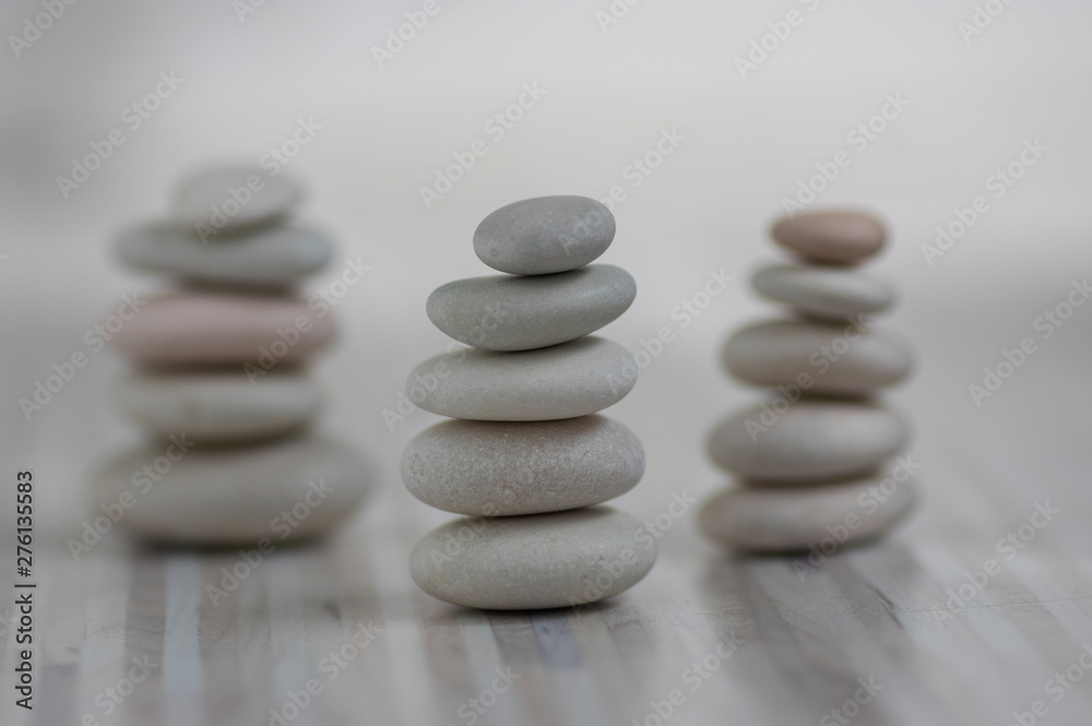 Harmony and balance, three cairns, simple poise pebbles on wooden light white gray background, simplicity rock zen sculpture Harmony and balance, three cairns, simple poise pebbles on wooden light white gray background, simplicity rock zen sculpture