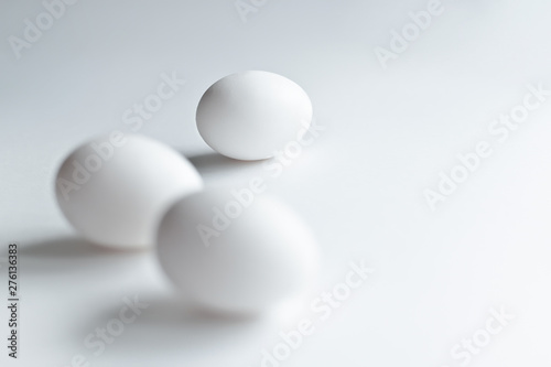 White chicken eggs on white background.