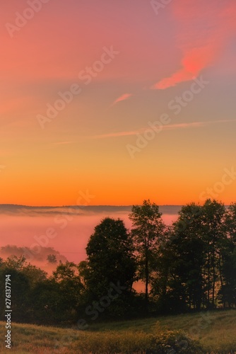 Beautiful morning sunrise in July over the Venango Valley in northwest Pennsylvania. Countryside landscape with trees, vertical orientation.