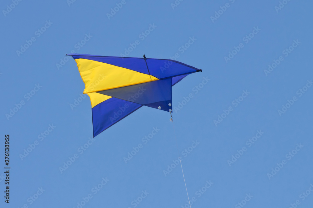 Kite in the colors of the national flag of Ukraine in the blue sky