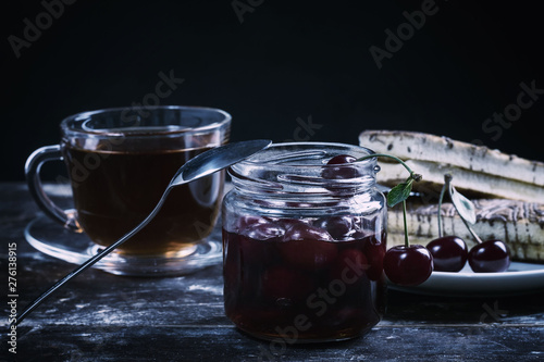 Cherry jam and tea on a wooden table
