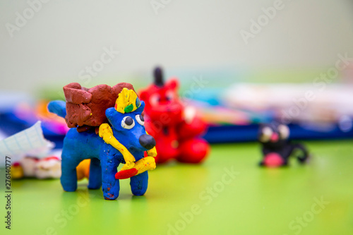 children's figures from plasticine on a bright green background