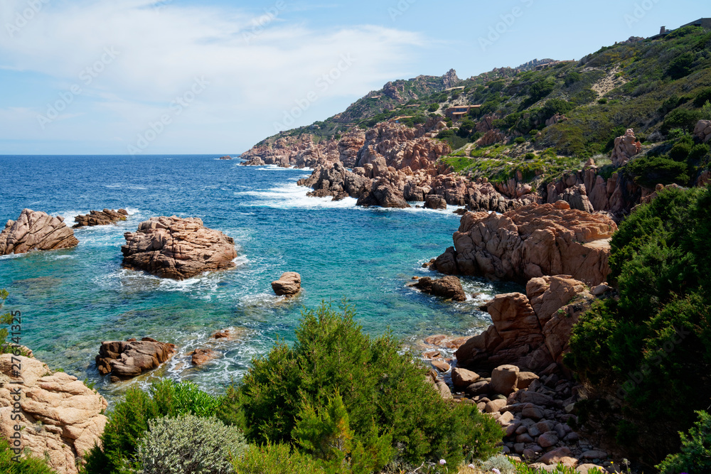Rugged red rock formation at a turquoisebeach at La Sorgente, Costa Paradiso in Sardinia (Italy) with turquoise blue sea