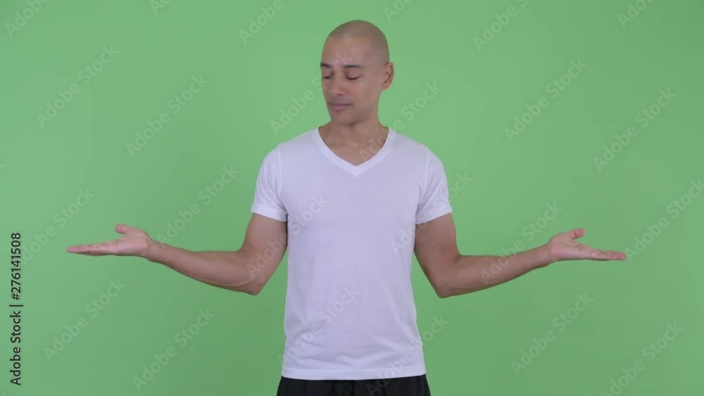 Happy handsome bald man comparing something Happy handsome bald man comparing something