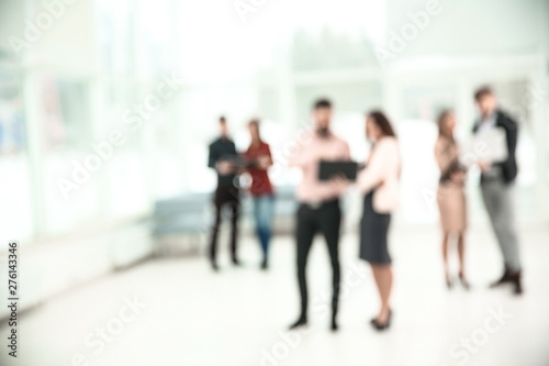 blurred image of a group of business people talking in the office lobby. photo with copy space