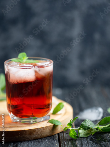 Red cocktail with ice and mint close-up