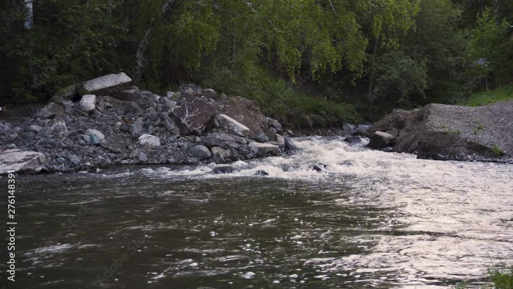 Rushing mountain stream of water flows into the river Rushing mountain stream of water flows into the river