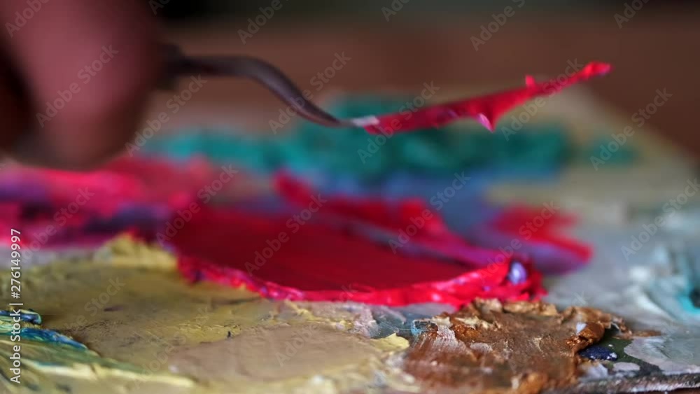 artist mixing and blending paint on a palette artist mixing and blending paint on a palette