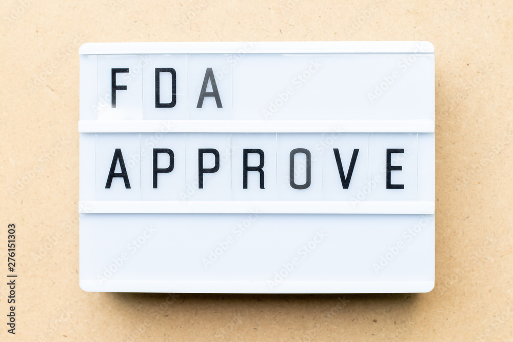 Fototapeta premium White lightbox with word fda approved on wood background