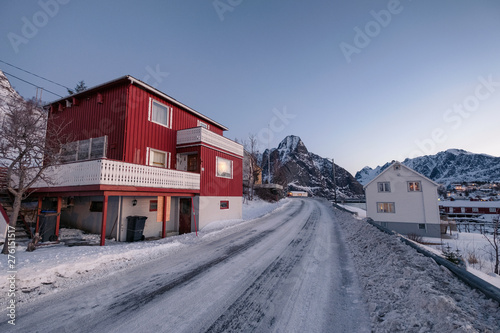 Red house with snow mountain in fishing village on winter